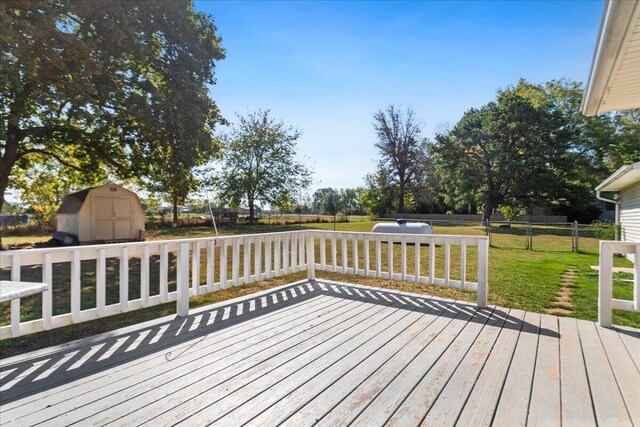 wooden deck featuring a yard and a storage unit