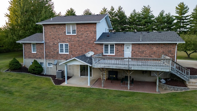 rear view of property featuring a deck, a lawn, central AC unit, and a patio area