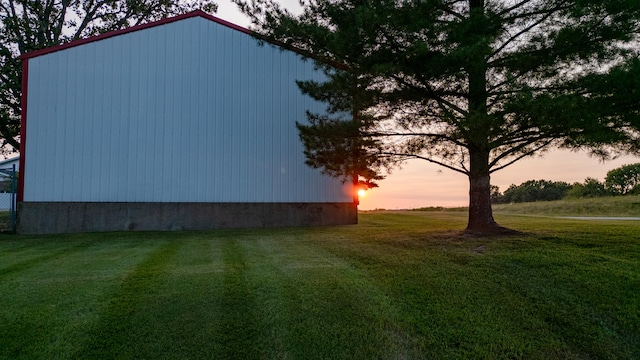 property exterior at dusk featuring a yard