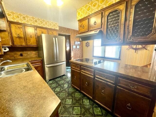 kitchen with stainless steel refrigerator, black electric stovetop, and sink