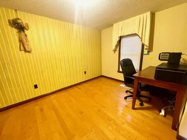 office space with a textured ceiling and light hardwood / wood-style flooring