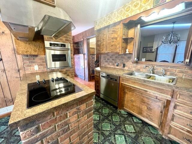 kitchen featuring sink, a notable chandelier, stainless steel appliances, decorative backsplash, and exhaust hood