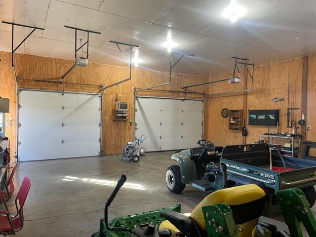 garage with a garage door opener and wooden walls