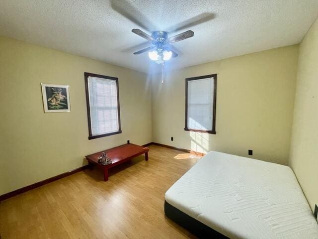 unfurnished bedroom with a textured ceiling, ceiling fan, and light hardwood / wood-style floors