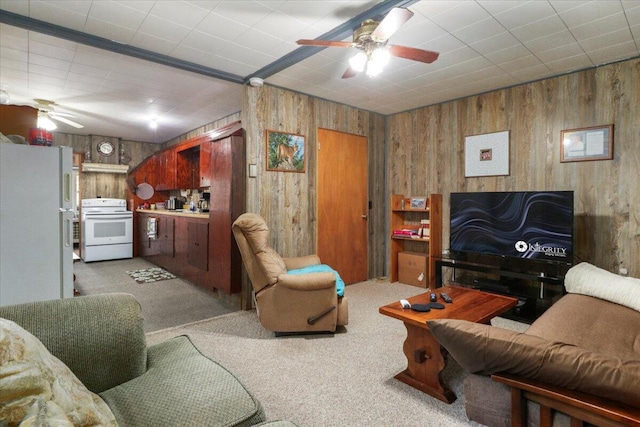living area featuring light colored carpet, ceiling fan, and wooden walls