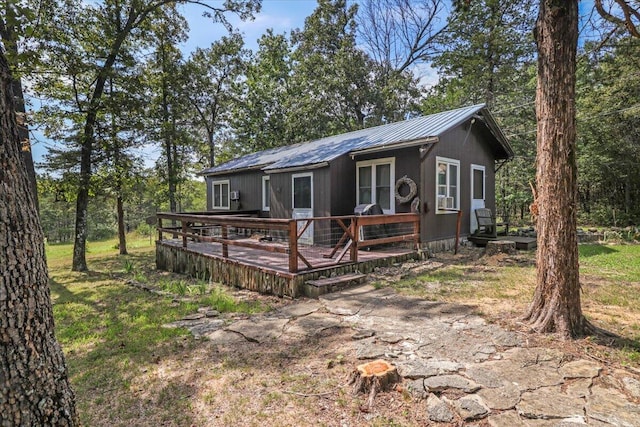 view of front of house with a wooden deck and a front lawn