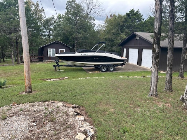 view of yard with driveway and an outbuilding