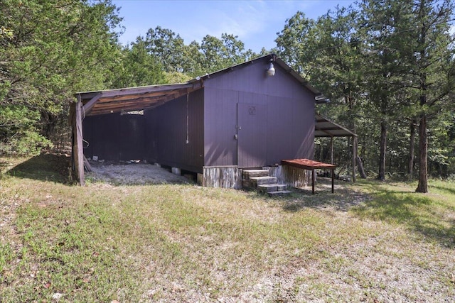 view of outdoor structure featuring a carport and an outbuilding