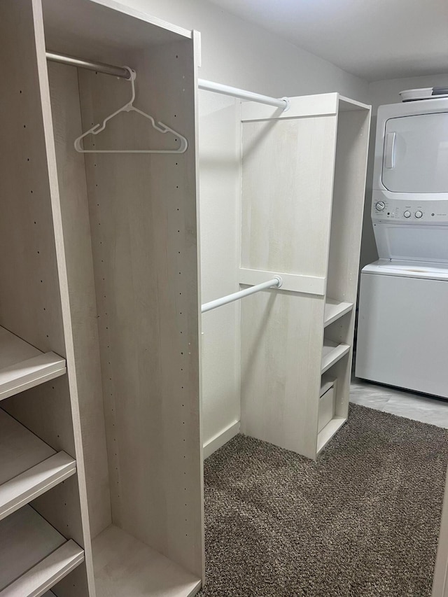 walk in closet with carpet floors and stacked washer and clothes dryer