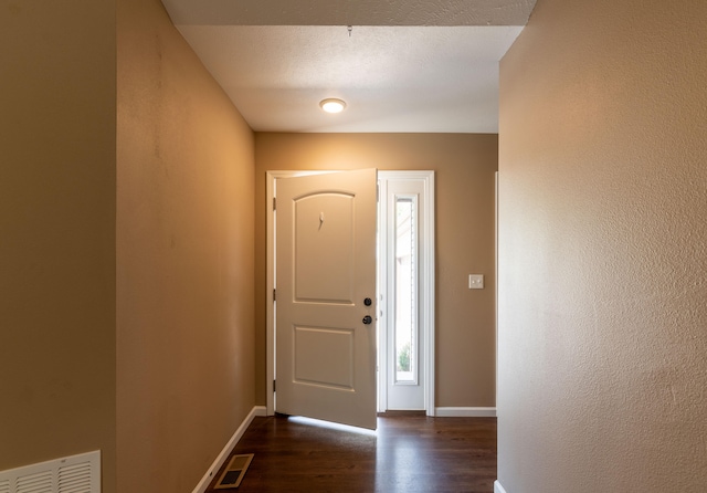 entryway with a textured ceiling and dark hardwood / wood-style floors