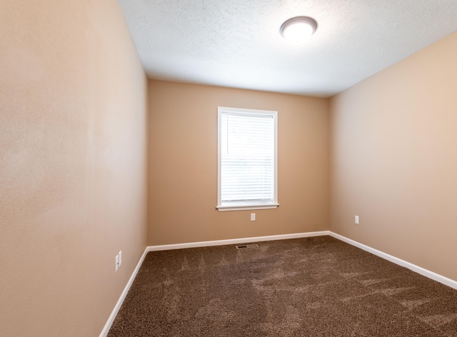 carpeted empty room featuring a textured ceiling