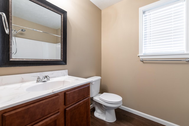 bathroom featuring hardwood / wood-style floors, vanity, walk in shower, toilet, and a textured ceiling