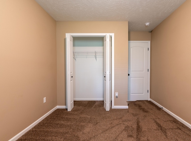 unfurnished bedroom with a textured ceiling, a closet, and carpet flooring