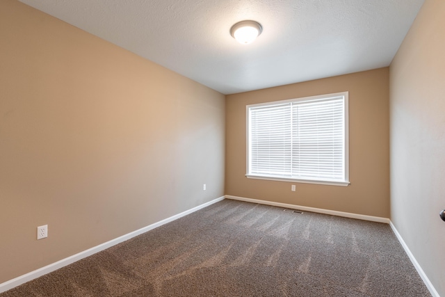 carpeted spare room with a textured ceiling