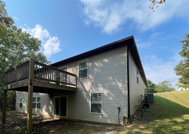 back of house featuring a deck, a lawn, and central air condition unit