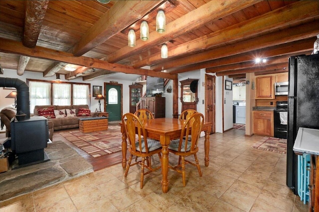 dining room featuring wood ceiling, washer / clothes dryer, a wood stove, and beamed ceiling