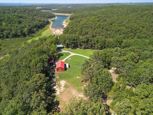 birds eye view of property with a view of trees and a water view