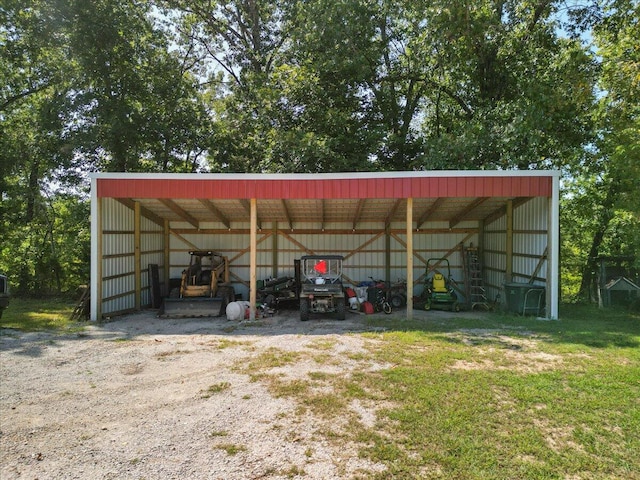 view of outdoor structure with a carport and a lawn