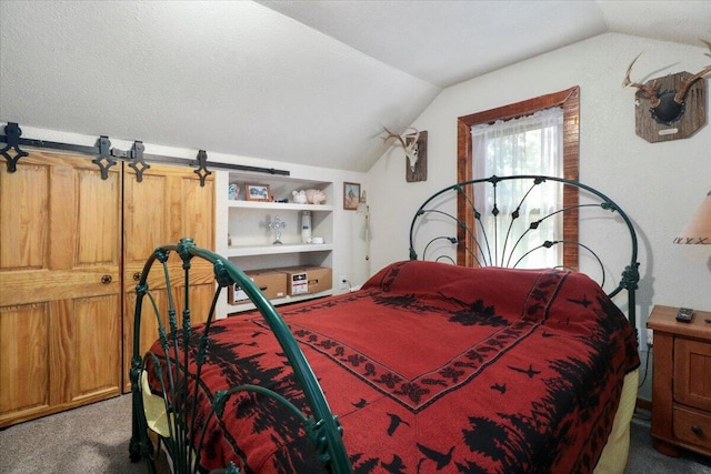 bedroom with a barn door, carpet floors, and vaulted ceiling