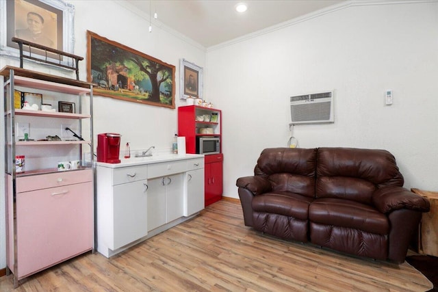 interior space with ornamental molding, white cabinets, light hardwood / wood-style floors, and an AC wall unit