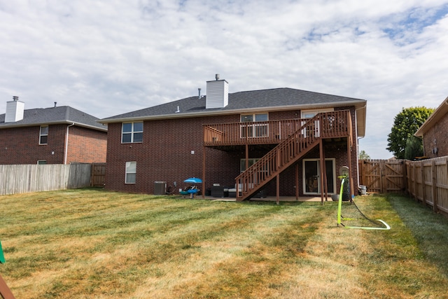 rear view of property with a wooden deck, central AC unit, and a lawn