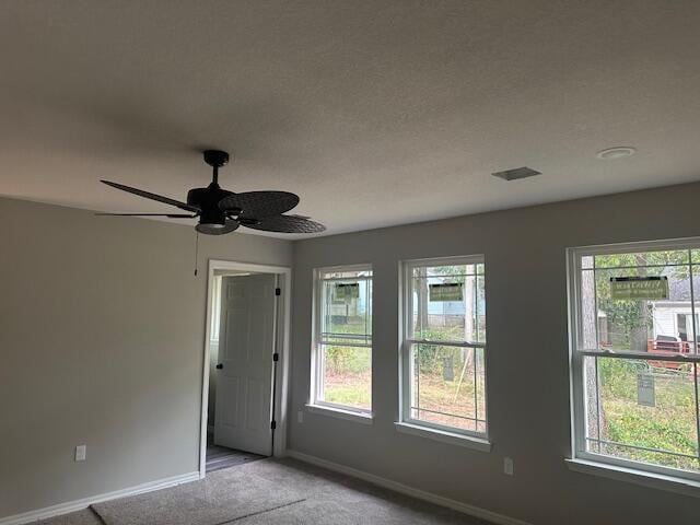 empty room with carpet floors, a textured ceiling, and ceiling fan