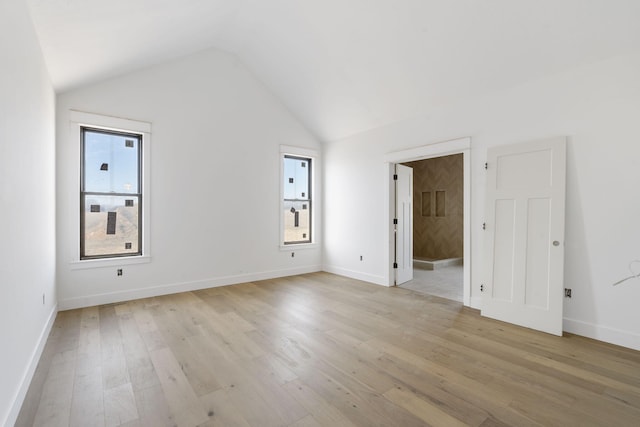 empty room with lofted ceiling and light wood-type flooring