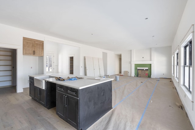 kitchen with a kitchen island, a fireplace, and light hardwood / wood-style floors