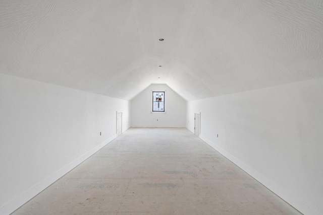 bonus room with vaulted ceiling and a textured ceiling