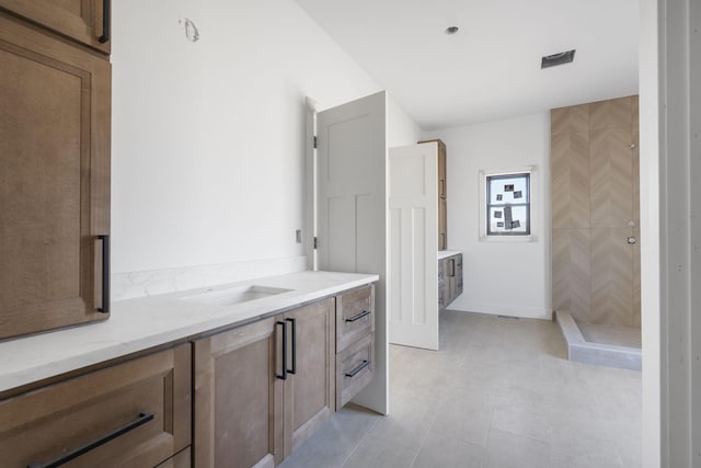 bathroom featuring tile patterned floors, vanity, and a shower