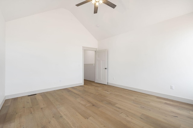 spare room featuring high vaulted ceiling, light wood-type flooring, a ceiling fan, and baseboards