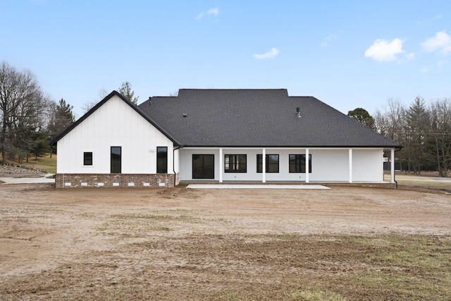 back of house featuring board and batten siding and a shingled roof