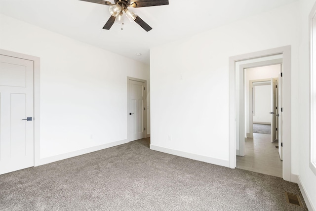 unfurnished bedroom featuring carpet floors, baseboards, visible vents, and ceiling fan