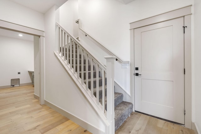 stairway with baseboards and wood finished floors