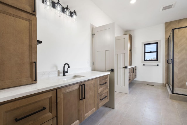 bathroom featuring visible vents, a shower stall, vanity, baseboards, and tile patterned floors