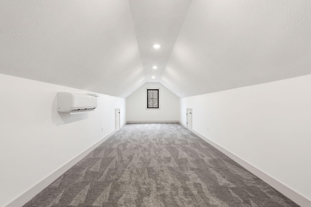 bonus room featuring lofted ceiling, a wall unit AC, recessed lighting, baseboards, and carpet