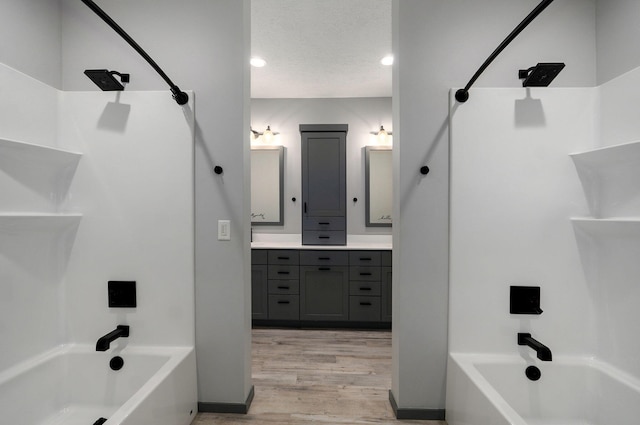 bathroom with hardwood / wood-style flooring, shower / bathtub combination, vanity, and a textured ceiling