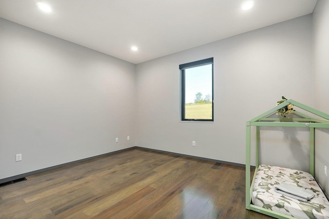 unfurnished room with dark hardwood / wood-style flooring