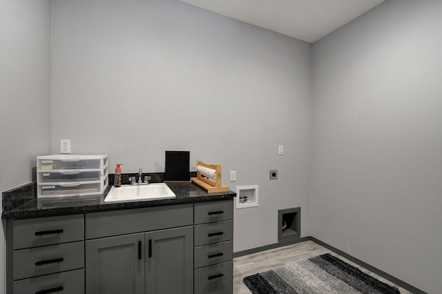 interior space featuring washer hookup, sink, cabinets, light hardwood / wood-style floors, and electric dryer hookup