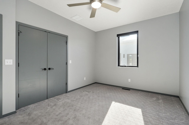 unfurnished bedroom featuring carpet floors, a closet, and ceiling fan