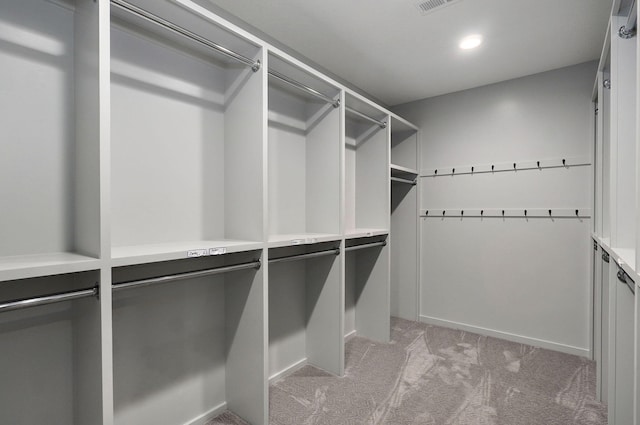 walk in closet featuring light carpet