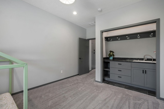 bedroom with vaulted ceiling, sink, dark colored carpet, and a textured ceiling