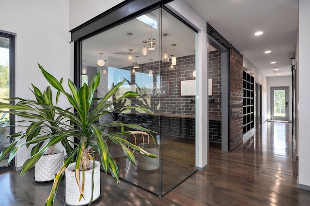 interior space with brick wall and dark wood-type flooring