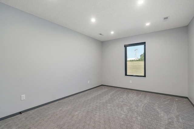 carpeted spare room with a textured ceiling