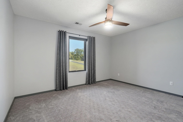 empty room with carpet flooring, ceiling fan, and a textured ceiling