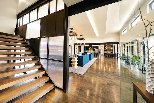 stairs with a towering ceiling and hardwood / wood-style floors