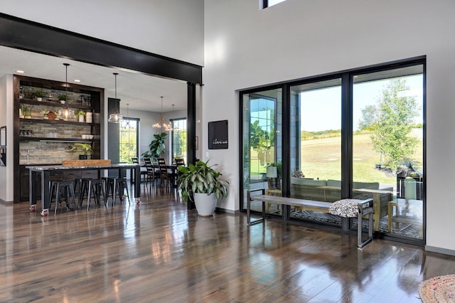 entryway with a healthy amount of sunlight, a chandelier, and dark hardwood / wood-style flooring