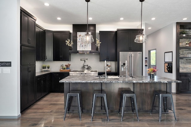 kitchen with premium range hood, a kitchen island with sink, and stainless steel appliances