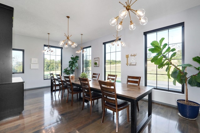 dining space with a wealth of natural light, dark wood-type flooring, and an inviting chandelier