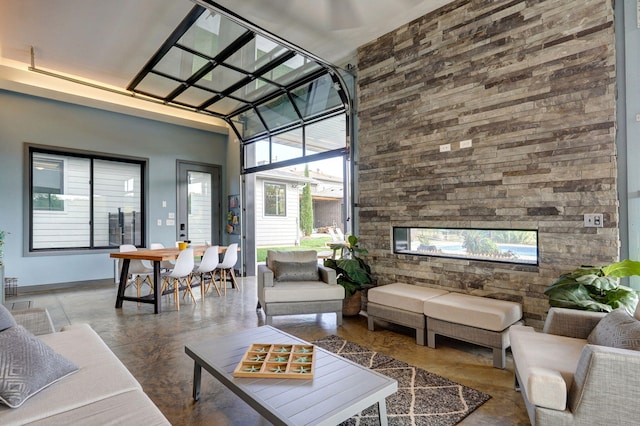 living room with a high ceiling, plenty of natural light, and concrete floors